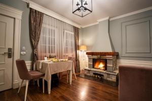 uma sala de jantar com uma mesa e uma lareira em PalmaNova Resort em Tirana