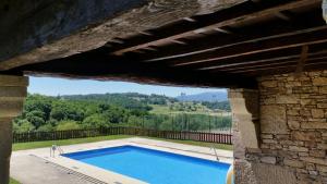 a swimming pool in a building with a stone wall at Pazo de Bendoiro in Bendoiro