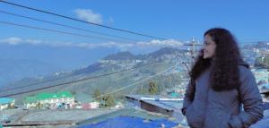 Une jeune femme debout au sommet d'une montagne dans l'établissement Laskus , Darjeeling, à Darjeeling