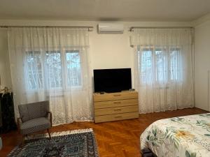 a bedroom with a television on a dresser with windows at VILLA TARA in Quercianella