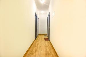 a hallway with white walls and a wooden floor at FabExpress Morjim Sea Waves in Old Goa