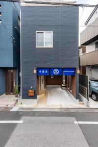 un edificio azul con un estacionamiento delante de él en Charming New Home Launch: Direct access to Narita & Haneda Airports, Shinjuku, and Disneyland; Close to Asakusa & Akihabara! en Tokio