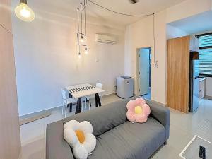 - un salon avec un canapé et une table dans l'établissement Mount Austin Palazio Homestay johor bahru, à Johor Bahru