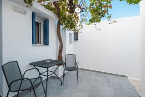 une table et des chaises sur une terrasse avec un arbre dans l'établissement Michalis Home, à Sérifos Chora