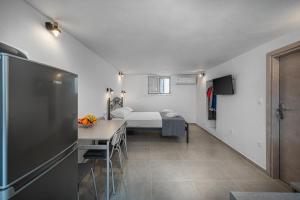 Habitación con cama, mesa y nevera. en Michalis Home, en Serifos Chora