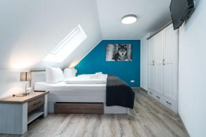 a bedroom with a bed and a blue wall at Ferienhaus Nationalparkidille in Rechlin +28 photos