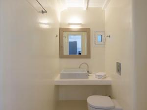 Baño blanco con lavabo y aseo en BayBees Sea View Residence en Platis Gialos