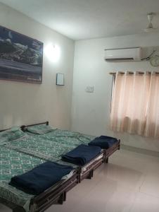 two twin beds in a room with a window at DWARKA BUNGALOW Only Family Full Bungalow in Dwarka