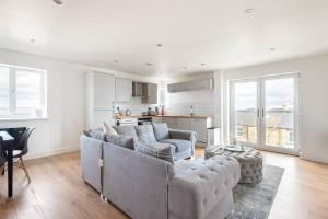 a living room with two couches and a kitchen at Luxurious 3-Bed Penthouse in Sheffield in Handsworth +10 photos