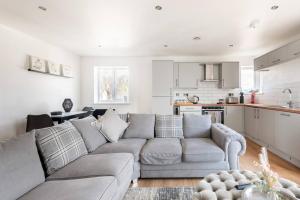 a living room with a couch and a kitchen at Luxurious 3-Bed Penthouse in Sheffield in Handsworth