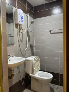 a bathroom with a toilet and a sink at Hotel Rim Global Subang in Subang Jaya