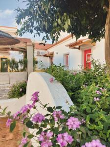 eine weiße Bank in einem Garten mit rosa Blumen in der Unterkunft Luxury Palm Suites in Reguengos de Monsaraz