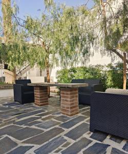 un patio in pietra con tavolo e sedie. di Luxury Palm Suites a Reguengos de Monsaraz