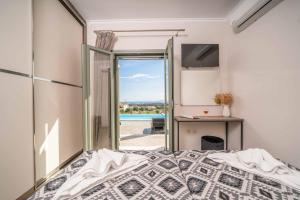 una camera da letto con un letto e una porta scorrevole in vetro di Casa Bella a Karavádhos Altre 20 foto