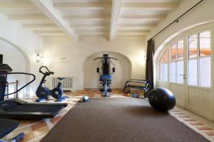 un gimnasio con cintas de correr y equipos de ejercicio en una habitación en QC Termeroma Spa and Resort, en Fiumicino