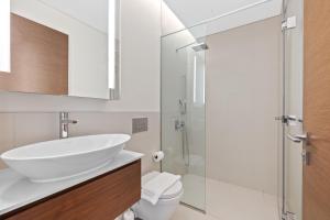 Spacious 2 Bedroom Luxury Apartment, City Walk Dubai في دبي: حمام أبيض مع حوض ومرحاض