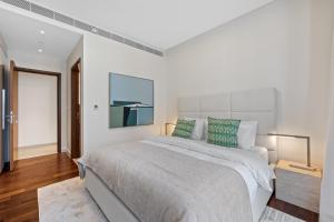 a white bedroom with a large bed with green pillows at Spacious 2 Bedroom Luxury Apartment, City Walk Dubai in Dubai