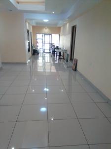 a large white tiled hallway with a table and chairs at Morning Star Lodge. in Lirahalibonoe