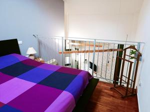 a bedroom with a colorful bed and a balcony at Il loft di Nina in Florence