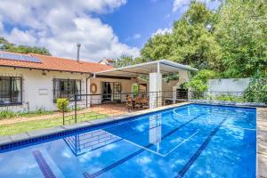 a swimming pool in front of a house at The Spanish House in Centurion