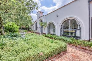 an exterior of a white building with a garden at The Spanish House in Centurion