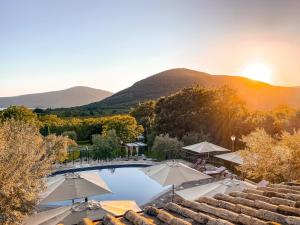 カプラローラにあるAgriturismo La Valle Di Vicoのパラソルと山々のあるプールの景色を望めます。