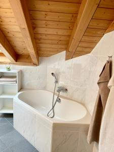 博斯特朗的住宿－Haus Himmelswies Sommerbergbahnen Kostenlos，带浴缸的浴室和木制天花板