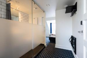 a glass partition in a room with a mirror at Milling Hotel Ritz Aarhus City in Aarhus