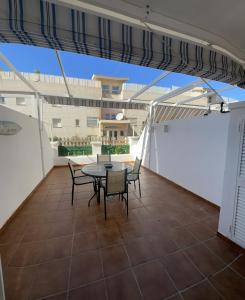 uma varanda com uma mesa e cadeiras e um edifício em apartamento torrequebrada em Benalmádena