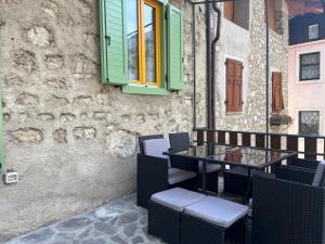 una mesa y sillas frente a un edificio en Borgo Bliss Apartment, en Tenno