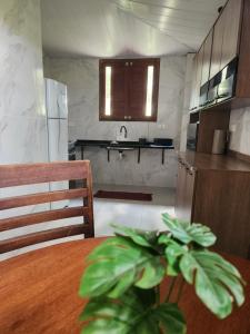 una cucina con tavolo in legno e pianta di Casa Campo - Domo do Matto a Garanhuns