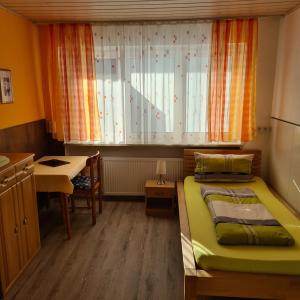 ランゲンブルックにあるPension Wolkensteinのベッドと窓が備わる小さな客室です。