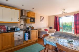 a kitchen and a living room with a table at Wheel Cottage, Landrake in Saltash