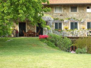 a stone house with a table in the yard at Il Glicine in Zimone