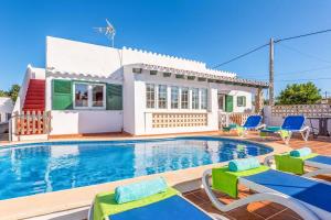 a villa with a swimming pool in front of a house at Can Quique in Cala'n Porter