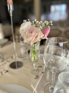 un jarrón de flores sentado en una mesa con gafas en Belsoggiorno, en San Remo