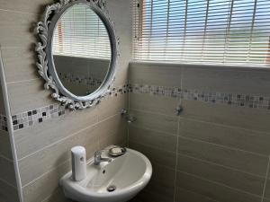 W łazience znajduje się umywalka i lustro. w obiekcie INTERPRO w mieście Bloemfontein