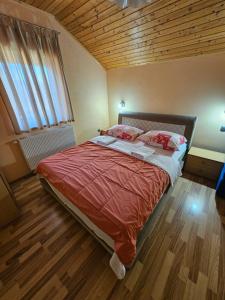 a bedroom with a large bed with a wooden ceiling at House Mirjana in Smoljanac