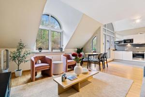 an attic living room with a table and chairs at Beggen 2BR, Cozy, Modern Living in Luxembourg