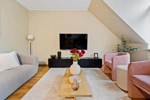 a living room with a vase of flowers on a coffee table at Beggen 2BR, Cozy, Modern Living in Luxembourg