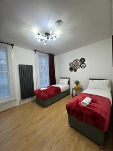 a bedroom with two beds and a fan at Kings Cross-Euston Apartment in London