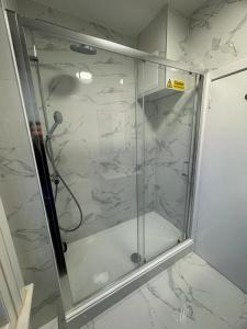a shower with a glass door in a bathroom at Kings Cross-Euston Apartment in London