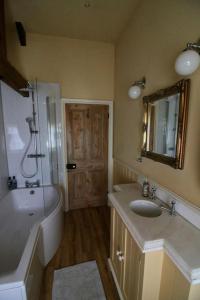 a bathroom with a tub and a sink and a bath tub at Characterful Yorkshire cottage, beautiful views in York