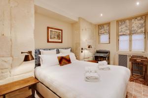 een slaapkamer met een groot wit bed en een bureau bij Pick A Flat's Apartments in Saint Germain - Paul-Louis Courier in Parijs