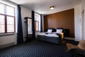 Pokój hotelowy z łóżkiem i lustrem w obiekcie Milling Hotel Ritz Aarhus City w mieście Aarhus