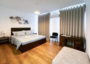 a bedroom with a bed and a desk and a chair at Lisboa Intendente 3Bedroom Apartment with Balcony in Lisbon