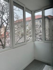 ein leeres Zimmer mit vier Fenstern in einem Gebäude in der Unterkunft Sweet Chic Home in Timişoara