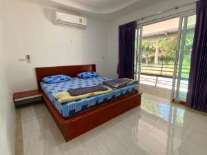 a bedroom with a bed and a large window at Firdous Guesthouse in Ban Khlong Hia