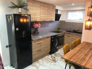 a kitchen with a black refrigerator and a table at Appartement RDC dans une Villas in Montpellier