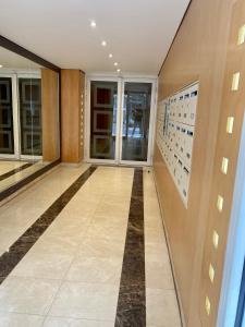 een hal van een gebouw met glazen deuren en tegelvloeren bij Luxury Appartement with terasse - 15mn from Champs-Elysée in Courbevoie